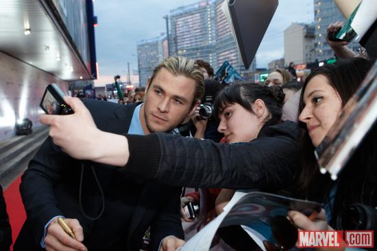Chris Hemsworth takes photos with fans at the Moscow premiere of Marvel's The Avengers